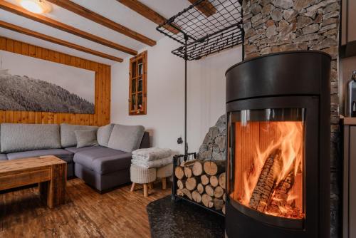 a living room with a fireplace and a couch at Chaloupka na stráni in Ostravice