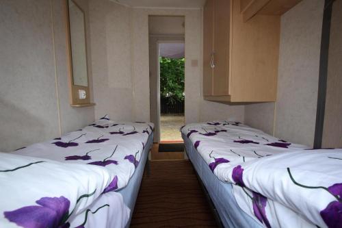 dwa łóżka w pokoju z oknem w obiekcie Bungalow, Mrzezyno w mieście Mrzeżyno