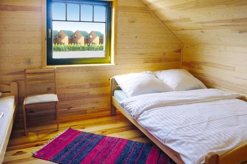 a bed in a wooden room with a window at Terraced Houses, Sarbinowo in Sarbinowo