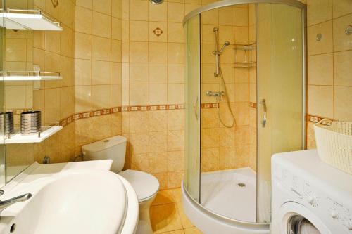 a bathroom with a toilet and a shower and a sink at Holiday flat, Kolobrzeg in Kołobrzeg