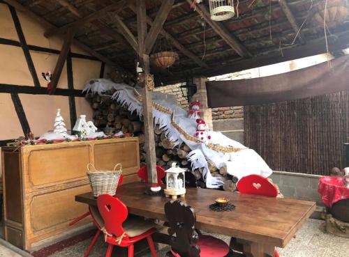 une salle à manger avec une table et des chaises rouges dans l'établissement Entre ville & campagne (jardin avec rivière), à Plobsheim