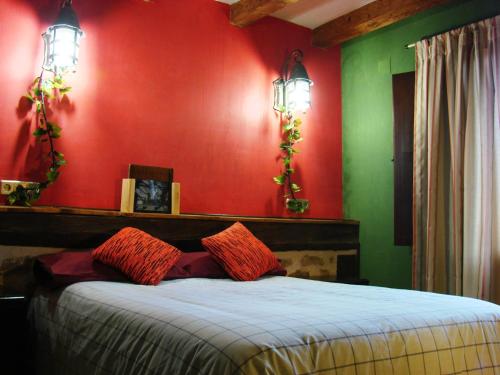 1 dormitorio con paredes rojas y verdes y 1 cama en La Hijuela, en Navafría
