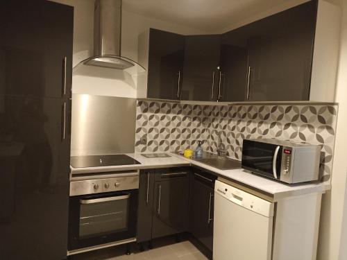 a kitchen with a microwave and a stove top oven at Gite Haute Epine "Ma Vie Là" in Haute-Épine