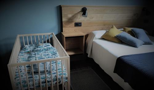 a bedroom with two twin beds and a crib at Prao del Molin in Cangas del Narcea