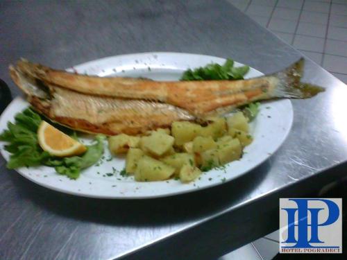 a plate of food with a fish and vegetables at Hotel Pogradeci in Pogradec