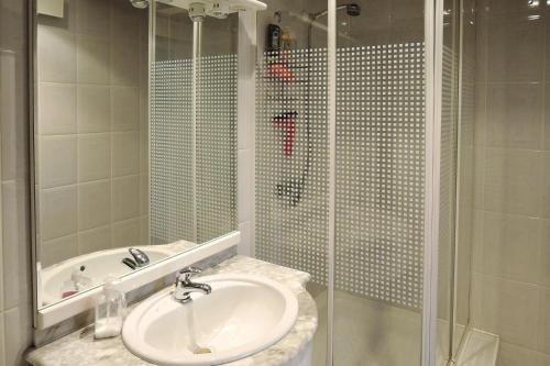 uma casa de banho branca com um lavatório e um chuveiro em holiday home, Stepnica em Stepnica