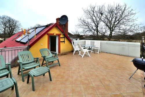 a patio with chairs and a house with a grill at Cottage by Ostrowieckie Lake with Private Beach in Kosierzewo
