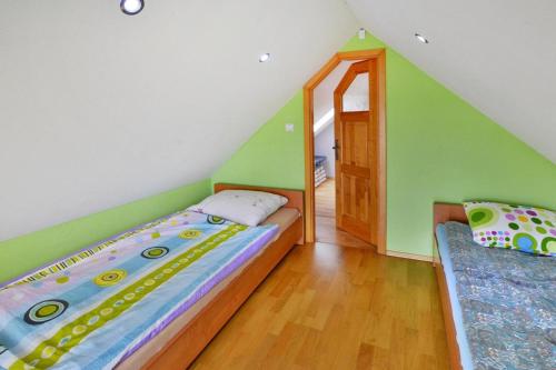 a attic bedroom with a bed and a window at Cottage by Ostrowieckie Lake with Private Beach in Kosierzewo