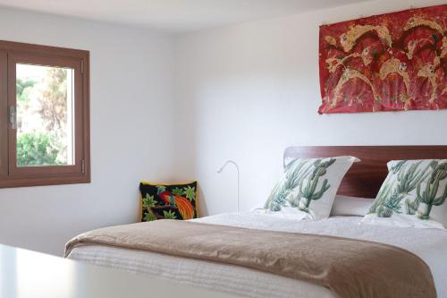 a bedroom with a bed with white sheets and a window at Finca La Punta in Icod de los Vinos