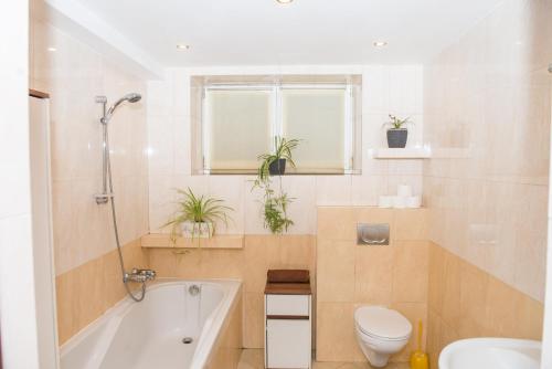 Un baño con bañera, inodoro y lavabo. en Parkowa House, en Cracovia