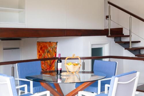 a glass table with a basket of fruit and a bottle of wine at Finca La Punta in Icod de los Vinos