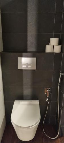 a bathroom with a white toilet in a black wall at Leśniczówka Kalina in Wetlina