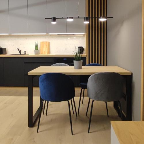 a dining room table with two chairs and a counter at Lake Chill - MAZURIA APARTAMENTY in Ostróda