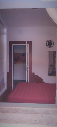 a room with a red bed and a door at Santo António's Guesthouse in Cascais