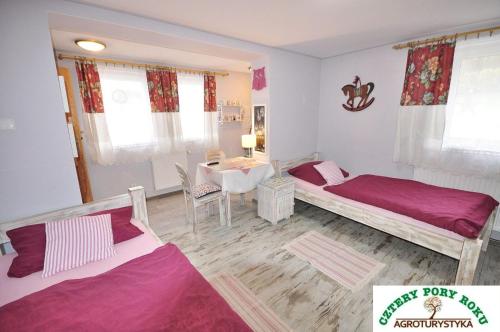 Kleines Zimmer mit 2 Betten und einem Tisch in der Unterkunft Cztery Pory Roku in Jeżów Sudecki