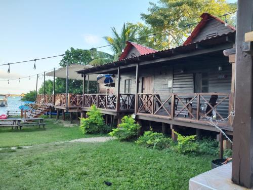 a wooden house with a deck next to the water at Papitos Bacalar Hotel and Marina in Bacalar