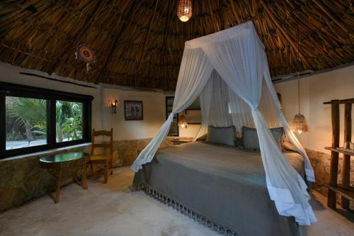 
a large bed with a canopy over it at Diamante K - Quiet zone of the beach in Tulum
