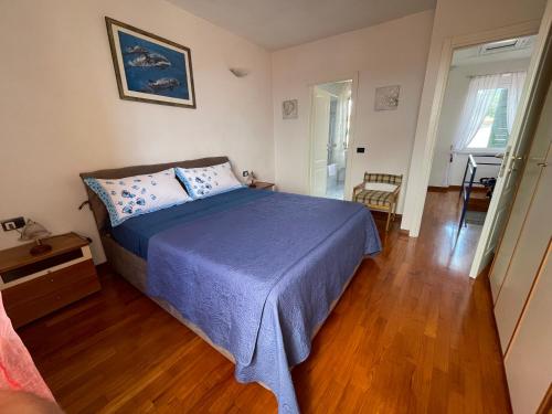 Schlafzimmer mit einem Bett und Holzboden in der Unterkunft LE SOLEIL DOREE' MAISON Wi-Fi VACATIONS LERICI 5 TERRE in Pitelli