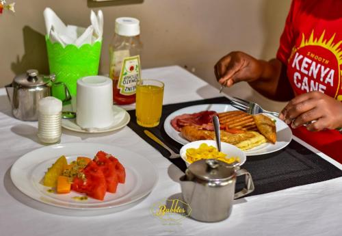 a table with two plates of breakfast food on it at Bubbles Lodge Kinangop in South Kinangop
