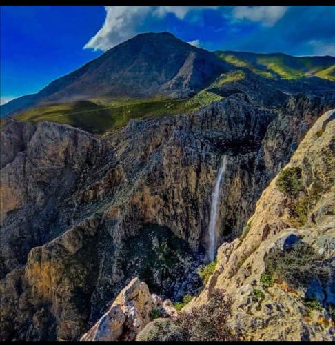a waterfall on the side of a mountain at Wooden House at the Mountain-private in Paránimfoi