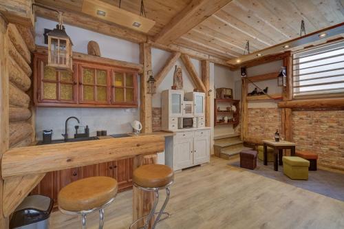 - une cuisine avec des murs en bois et des tabourets en bois dans une cabine dans l'établissement Apartamenty Krynica-Zdrój Karolina, à Krynica-Zdrój