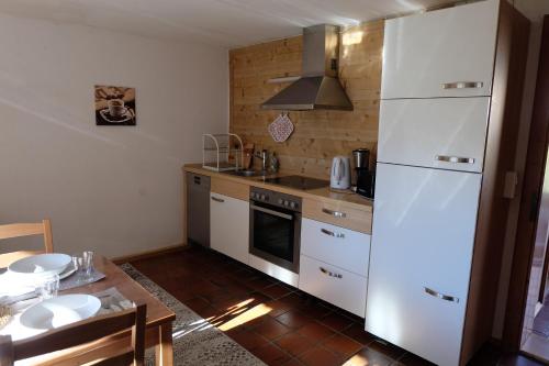 a kitchen with a white refrigerator and a table at Am Jenbach in Bad Feilnbach