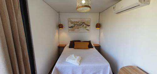 コロニア・デル・サクラメントにあるFLORANVICk incluye 2 bicis!!の小さな客室で、ベッド1台(黄色い枕付)が備わります。