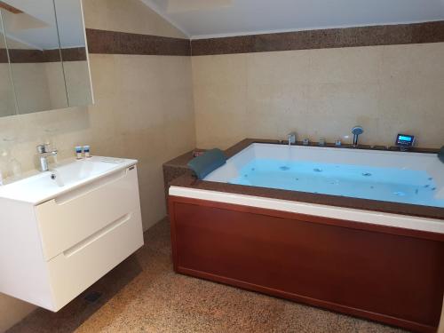 a bathroom with a blue tub and a sink at Mega Mall Monza Super Spa in Bucharest