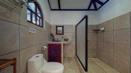 a bathroom with a toilet and a shower at The Scarlet Villas in Ojochal