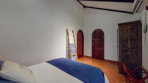 a bedroom with a bed and two wooden doors at The Scarlet Villas in Ojochal