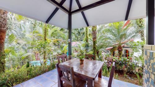a wooden table with chairs and an umbrella on a patio at The Scarlet Villas in Ojochal