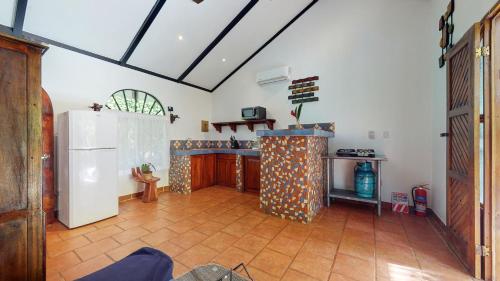 a kitchen with a white refrigerator and a tile floor at The Scarlet Villas in Ojochal
