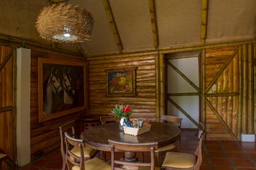 a wooden dining room with a table and chairs at Hacienda Charrascal Coffe Farm in Manizales