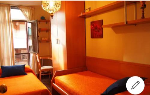 グラナダにあるEl apartamento de Marylinのベッド2台と窓が備わる小さな客室です。