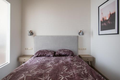 een bed met een paars dekbed in een slaapkamer bij Klevų apartamentai in Klaipėda