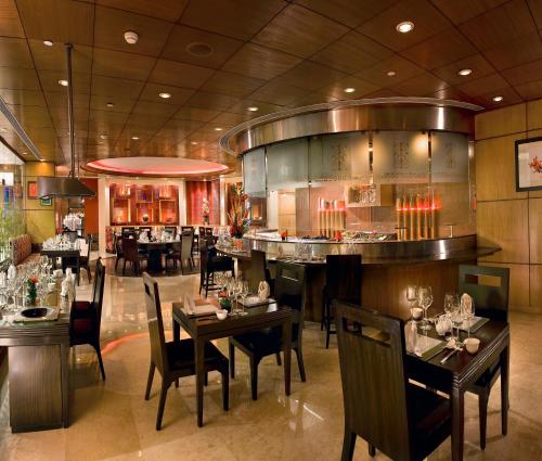 a restaurant with tables and chairs and a bar at Radisson Blu MBD Hotel Noida in Noida