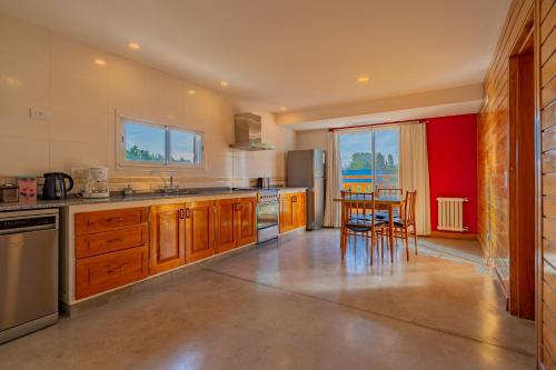 a kitchen with wooden cabinets and a table and chairs at Hotel de campo Haras Los Abuelos in Sierra de los Padres