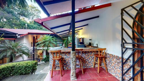 an outdoor kitchen with a bar with stools at The Scarlet Villas in Ojochal
