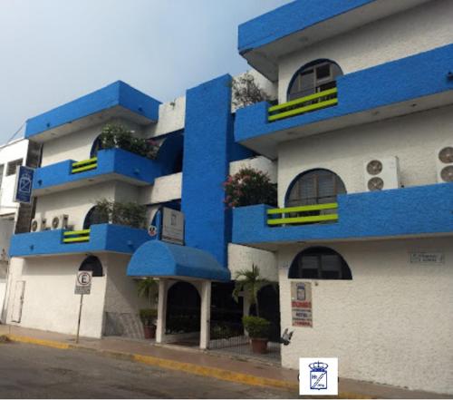 a blue and white building with plants on the balconies at Hotel y Restaurante Ritz de Tabasco in Villahermosa