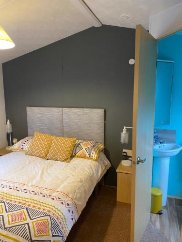 ein Schlafzimmer mit einem Bett mit einer grauen Wand in der Unterkunft Lakeside in Chichester