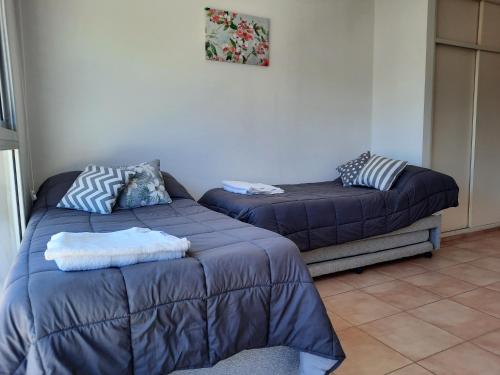 ein Wohnzimmer mit einem Bett und einem Futon in der Unterkunft Monoambiente Rivadavia in Cipolletti