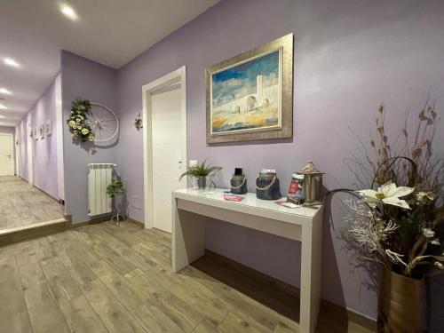 フィレンツェにあるPorta alla Croce Guest Houseの白いデスクと紫の壁が備わる客室です。