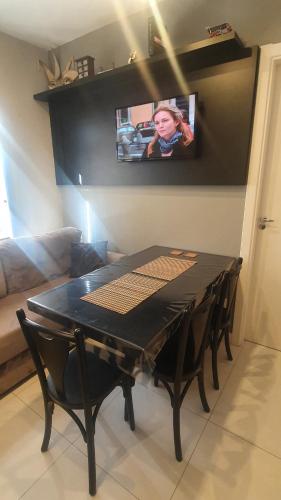 a black table with chairs and a tv on a wall at Lindo apto, 100metros da praia, na Av Brasil com a Av Central melhor localização in Balneário Camboriú