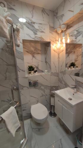 Un baño blanco con inodoro y lavabo. en Apartament 303 Planeta, en Mielno