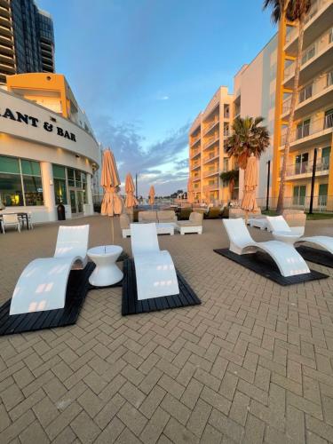 a group of white chairs and tables on a sidewalk at Peninsula Island Resort & Spa - Beachfront Property at South Padre Island in South Padre Island