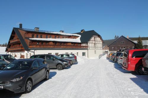 a parking lot with cars parked in the snow at Pila Kvilda in Kvilda