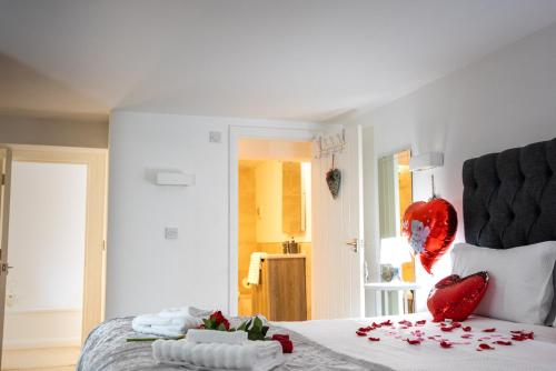 Un dormitorio con una cama con corazones rojos. en Dealhouse Apartments 1, en Huddersfield