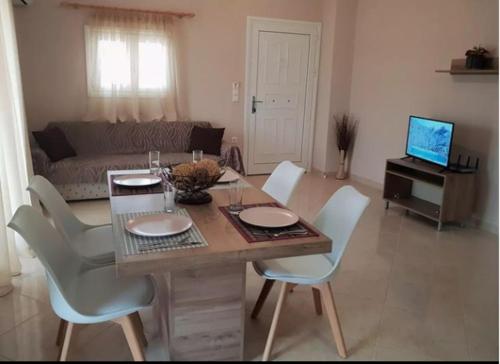 un soggiorno con tavolo, sedie e divano di Paschali apartment with 2 bedrooms in Ammoudia a Párga
