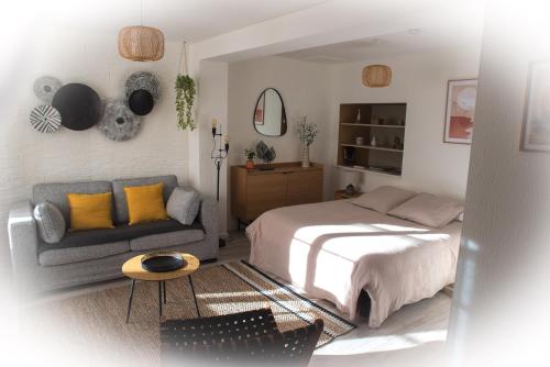 a bedroom with a bed and a couch at Calme et cosy in Obernai