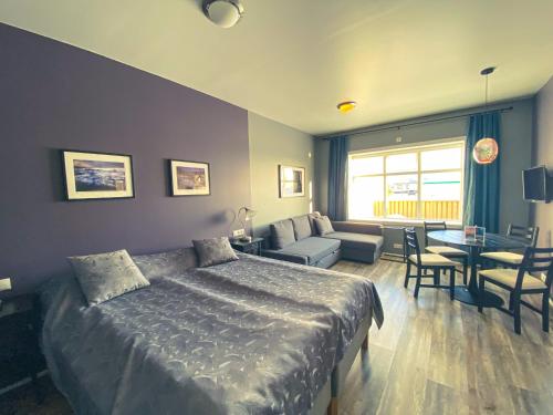 a bedroom with a bed and a living room at Bakki Apartments & Hostel in Eyrarbakki